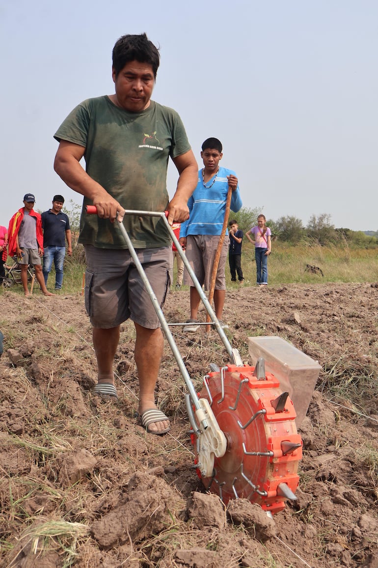 Carlos Miglietta haciendo una demostración con la máquina sembradora manual a rodillo, la cual facilita la aplicación técnica de las recomendaciones de siembra.