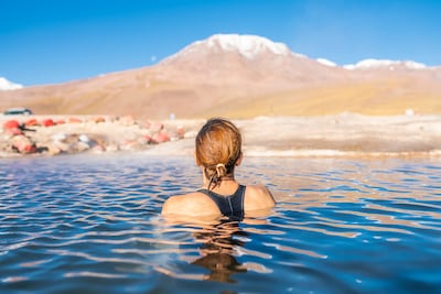Mujer tomando un baño en las aguas termales de los Géiseres del Tatio, en el desierto de Atacama, Chile.