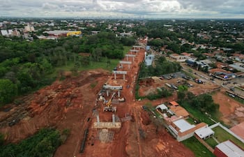 Vista aérea de la construcción de la autopista elevada en Luque, con maquinaria y cimientos visibles entre un entorno suburbano.