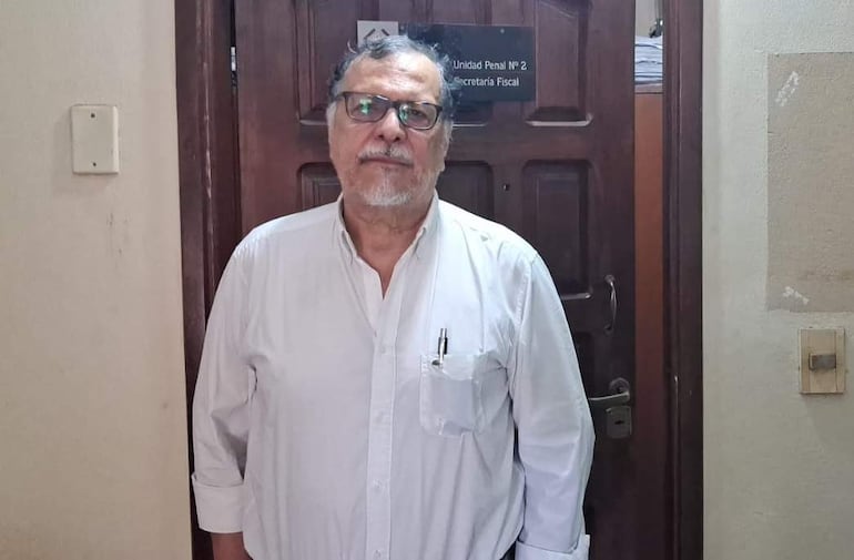 Hombre de pie frente a la puerta de la Unidad Penal N° 2, vistiendo una camisa blanca y con expresión seria.