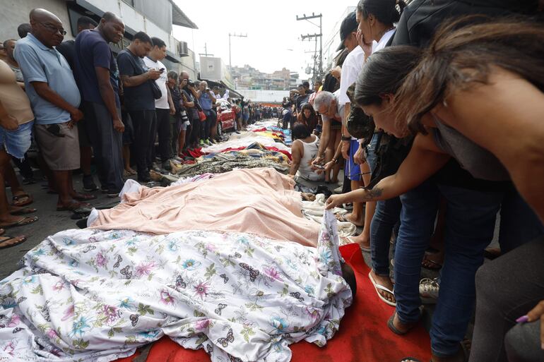 Una mujer observa un cuerpo sin vida en una calle este miércoles, en Río de Janeiro (Brasil). 