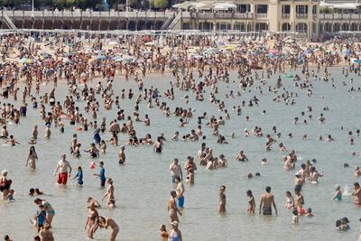 Cientos de personas alivian los efectos de las altas temperaturas este miércoles en la playa de La Concha de San Sebastián. Con posibles récords de calor en España y miles de hectáreas quemadas en Portugal, la península ibérica, en primera línea del calentamiento global en Europa, está en alerta este miércoles.