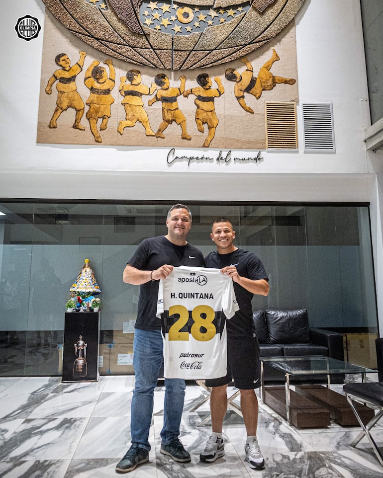 El presidente de Olimpia, Rodrigo "Coto" Nogués y el volante Hugo Quintana sostienen la camiseta franjeada, tras rubricar la extensión de contrato del excelente mediocampista.
