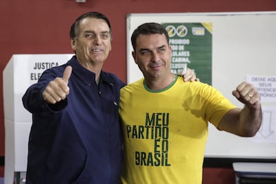Fotografía de archivo del 7 de octubre de 2018 que muestra al expresidente de Brasil, Jair Bolsonaro (i), posando junto a su hijo, Flavio Bolsonaro, después de la primera vuelta de las elecciones presidenciales de Brasil en 2018, en Rio de Janeiro (Brasil). El apellido Bolsonaro se volvió habitual en los expedientes de varios procedimientos judiciales en Brasil. Tanto el expresidente Jair, como sus cuatro hijos varones -Flávio, Carlos, Eduardo y Jair Renan-, fueron objeto de investigaciones, enjuiciamientos o condenas acusados de golpismo, blanqueo de capitales, pertenencia a organización criminal o coacciones.