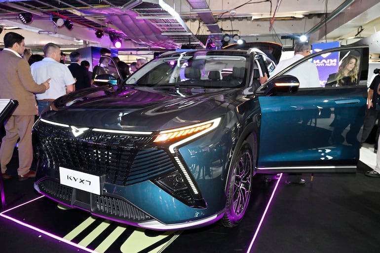 El SUV Kaiyi KYX7 destaca en primer plano, rodeado de asistentes interesados en su diseño moderno y atractivos detalles.