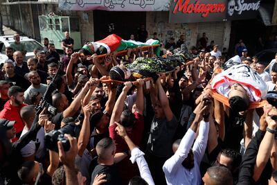 Una multitud carga con los cuerpos de militantes palestinos fallecidos durante enfrentamientos con fuerzas israelíes en Yenín, en la CIsjordania ocupada.