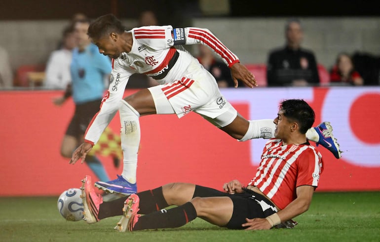 El delantero del Flamengo Bruno Henrique y el defensor de Estudiantes Santiago Núñez luchan por el balón durante el partido de fútbol de ida de las semifinales de la Copa Libertadores, en el estadio UNO Jorge Luis Hirschi.