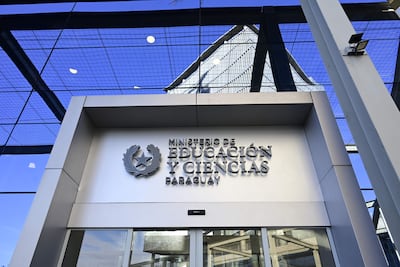 Fachada moderna del Ministerio de Educación y Ciencias de Paraguay, con el emblema institucional y cielo despejado.