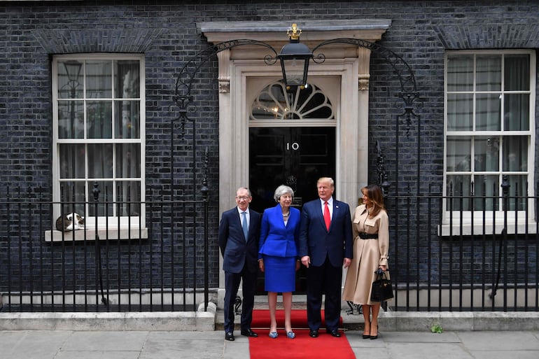 Larry el Gato está sentado en el alféizar de la ventana (I) mientras la primera ministra británica Theresa May (2I) y su esposo Philip May (I) saludan al presidente de Estados Unidos Donald Trump (2D) y a la primera dama Melania Trump (D) frente al número 10 de Downing Street, en Londres, el 4 de junio de 2019.
