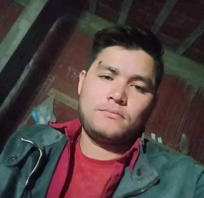 Selfie de Fernando Ariel Escobar Silva. Viste una camisa y remera roja con un abrigo oscuro.