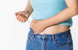 Mujer se aplica un fármaco contra la obesidad.