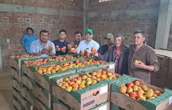 El titular del MAG, Carlos Giménez, junto a productores, muestran los tomates que fueron enviados a la Argentina.