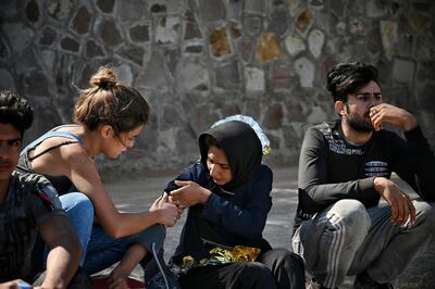 En la isla de Lesbos, Grecia, una voluntaria asiste a una mujer que cruzó el mar Mediterráneo desde Turquía.