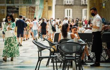 Un camarero atiende a los clientes en la terraza de un restaurante en Nápoles, Italia.