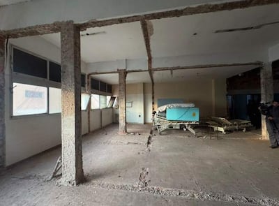 Interior del hospital con camas hospitalarias vacías, columnas expuestas y paredes desgastadas por el tiempo.