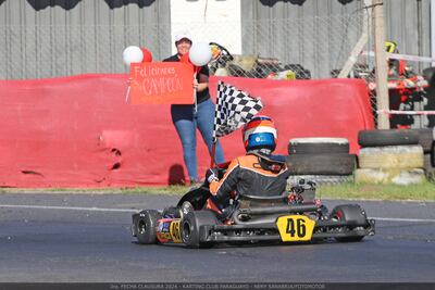 Con un cartel que dice “Felicidades, Campeón”, la madre de Alejandro Samaniego lo recibe al cruzar la meta.