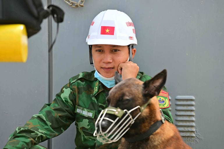 Un soldado de Vietnam descansa junto a un perro durante las labores de búsqueda en Catia La Mar, estado de La Guaira, Venezuela, el 5 de julio de 2026, tras los terremotos gemelos del 24 de junio.