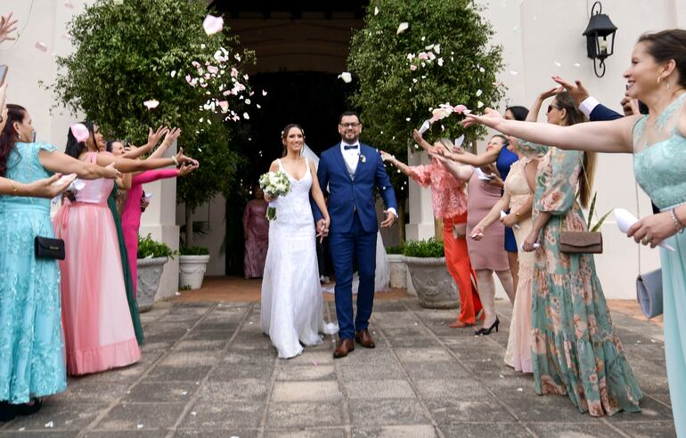 A la salida de la iglesia los novios fueron recibidos por sus invitados quienes lanzaron pétalos blancos naturales.