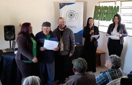 Eleuterio Valdez (86) recibe con alegría su certificado de finalización del curso de alfabetización digital. Lo acompañan en la imagen el profesor Roberto Godoy de la UNP y la presidenta de la Asociación, Cristina Ozuna.