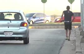 Una persona trotando por el asfaltado al no tener espacio en la vereda por las vallas metálicas que se encuentran en el lugar.