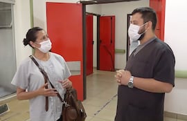 Karina Galeano, hija de Doña Paulina, conversa con el jefe de Urgencias de IPS Ingavi, Álvaro Benítez.