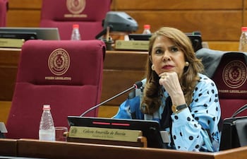 Senadora Celeste Amarilla, con cabello largo y vestido de puntos, escucha atentamente en un recinto legislativo.