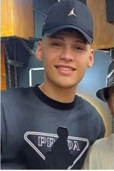 Jorge Ignacio Domínguez Medina sonriendo, lleva gorra, dimples visibles en su rostro, con fondo urbano difuso.