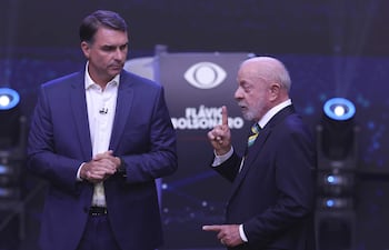 AME7366. SAO PAULO (BRASIL), 18/10/2026.- El presidente de Brasil y candidato a la reelección, Luiz Inácio Lula da Silva (d), y el opositor Flávio Bolsonaro, hablan en el primer debate presidencial este domingo, en la sede de Rede Bandeirantes en Sao Paulo (Brasil). Lula atacó a Bolsonaro vinculándolo a los mandatarios de Argentina, Javier Milei, y de EE.UU., Donald Trump, por su parte, el opositor respondió relacionando a su adversario con el jefe de Estado nicaragüense, Daniel Ortega, y con el depuesto presidente venezolano Nicolás Maduro. EFE/ Sebastiao Moreira