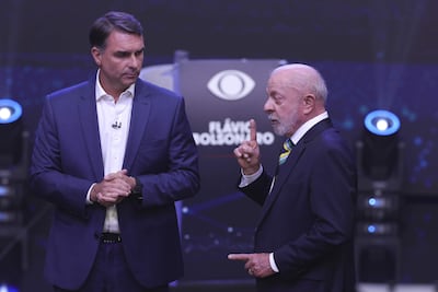 El presidente de Brasil y candidato a la reelección, Luiz Inácio Lula da Silva (d), y el opositor Flávio Bolsonaro, hablan en el primer debate presidencial este domingo, en la sede de Rede Bandeirantes en Sao Paulo (Brasil). Lula atacó a Bolsonaro vinculándolo a los mandatarios de Argentina, Javier Milei, y de EE.UU., Donald Trump, por su parte, el opositor respondió relacionando a su adversario con el jefe de Estado nicaragüense, Daniel Ortega, y con el depuesto presidente venezolano Nicolás Maduro. EFE/ Sebastiao Moreira
