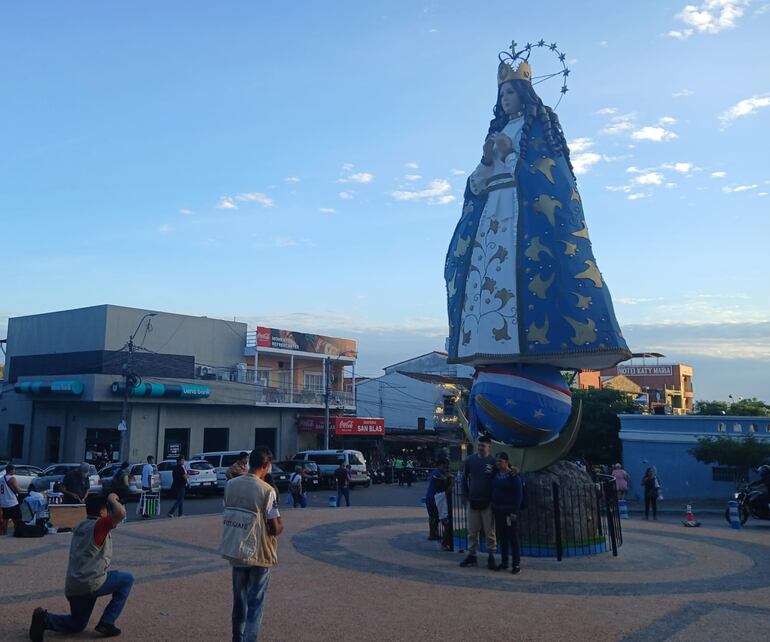 Los visitantes emocionados se toman una fotografía frente a la escultura de la Virgen de los Milagros de Caacupé.