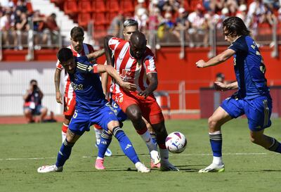 El jugador de la UD Almería Kone (c) disputa un balón con el jugador del Granada C.F Neva durante el partido celebrado esta tarde en Power Horse Stadium de Almería.