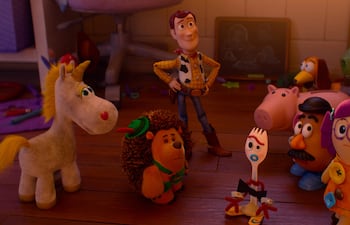 Muñeco de vaquero interactúa con un unicornio, erizo y otros juguetes en un ambiente acogedor y colorido.