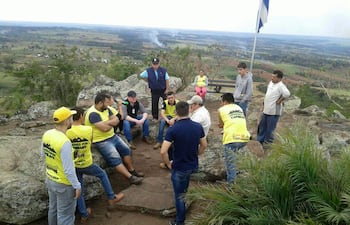 Integrantes de la Asociación de Jóvenes por Capiibary reunidos sobre el Cerro dos de Oro proyectando los trabajos en el lugar.