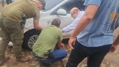 Agentes de Control de Automores verifcan el auto Kia Soluto blanco, que fue ubicado en la casa ocupada por el presunto lider de la banda de robacoches. El vehículo presentaba varios impactos de bala.
