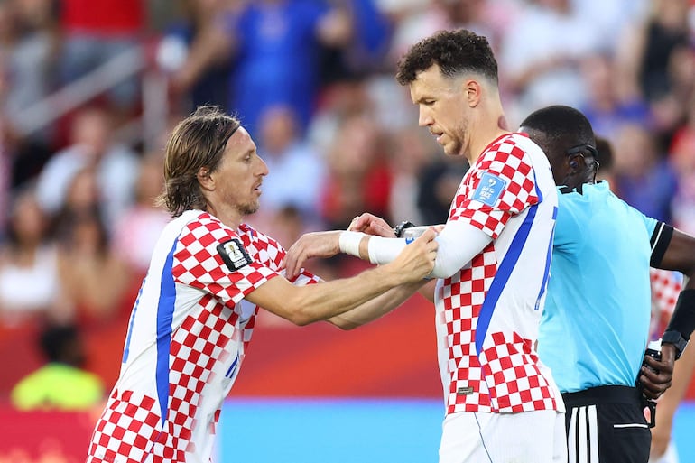 Modric coloca el brazalete de capitán a Ivan Perisic durante el partido.
