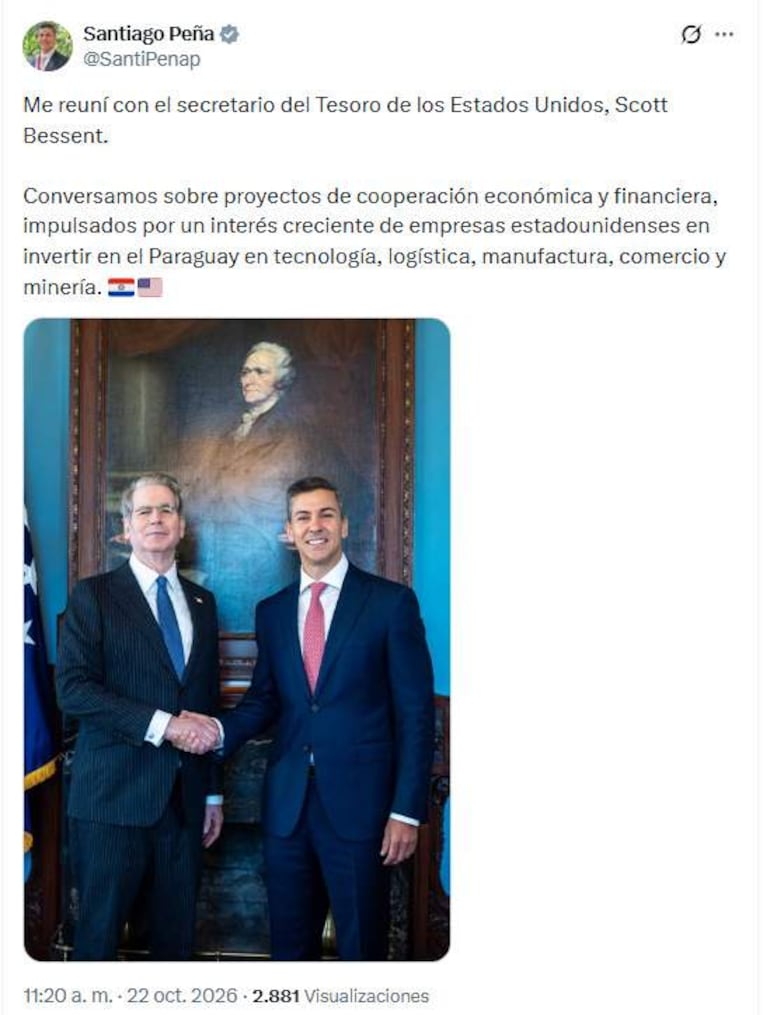 Santiago Peña en traje de rayas estrecho da la mano a Scott Bessent en traje azul en oficina gubernamental, ambos sonrientes.