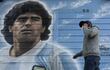 Una persona pasa junto a un mural pintado por el artista Marley afuera del estadio Diego Armando Maradona mientras la gente se reúne para conmemorar el segundo gol de la leyenda argentina contra Inglaterra durante la Copa Mundial de la FIFA México 1986 en su 35° aniversario, en Buenos Aires.
