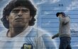 Una persona pasa junto a un mural pintado por el artista Marley afuera del estadio Diego Armando Maradona mientras la gente se reúne para conmemorar el segundo gol de la leyenda argentina contra Inglaterra durante la Copa Mundial de la FIFA México 1986 en su 35° aniversario, en Buenos Aires.