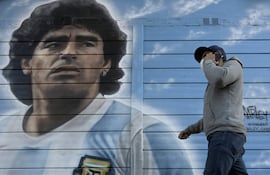 Una persona pasa junto a un mural pintado por el artista Marley afuera del estadio Diego Armando Maradona mientras la gente se reúne para conmemorar el segundo gol de la leyenda argentina contra Inglaterra durante la Copa Mundial de la FIFA México 1986 en su 35° aniversario, en Buenos Aires.