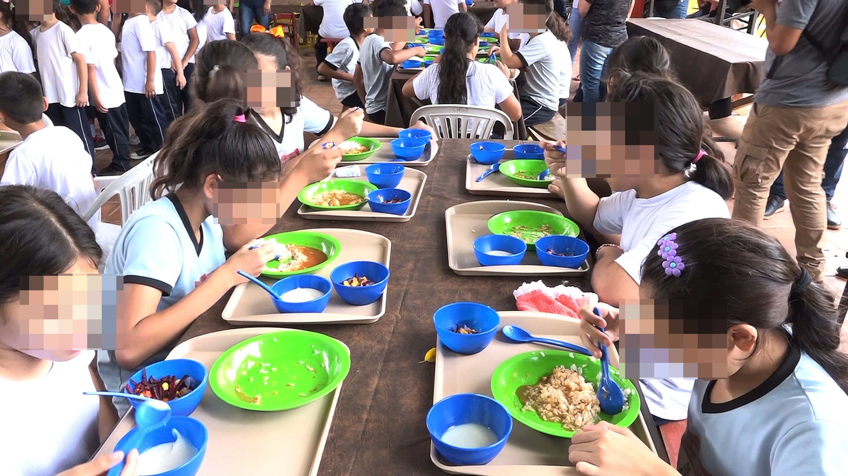 Alumnos almuerzan en el comedor de una escuela