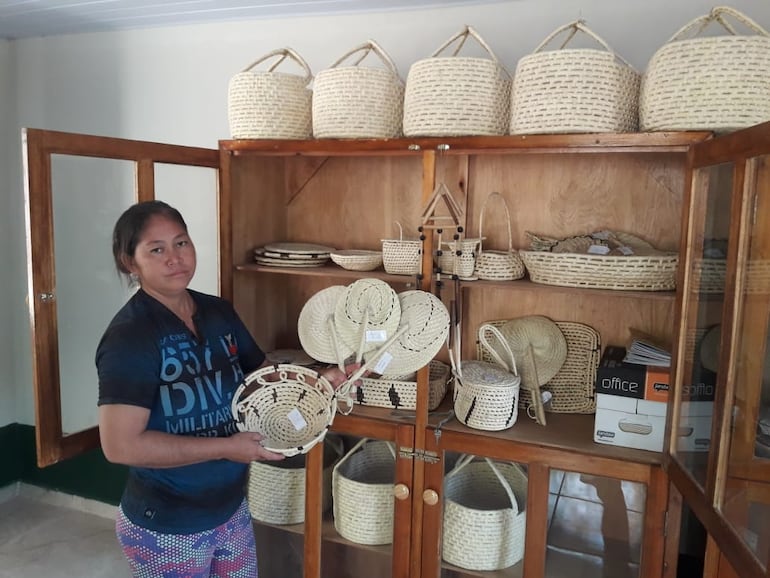 Mujer artesana Ishir, exibiendo los productos que fabrican en base a la hoja de palma.