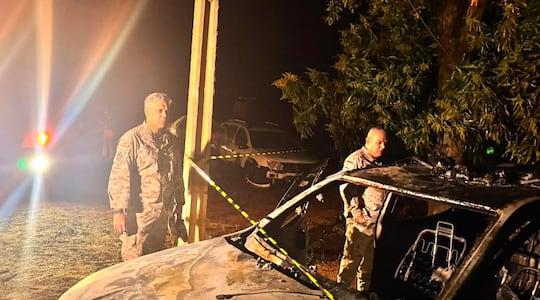 El subcomandante de la Policía, Feliciano Martínez, observa la patrullera quemada por el EPP en el puesto policial de la colonia Naranjito, Canindeyú. Atrás aparece el director de Investigaciones, Javier Flores.