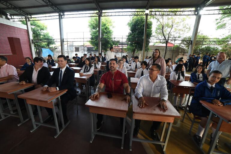 Óscar "Nenecho" Rodríguez (ANR-HC) sentado junto a funcionarios municipales en las sillas y mesas que entregó este viernes.