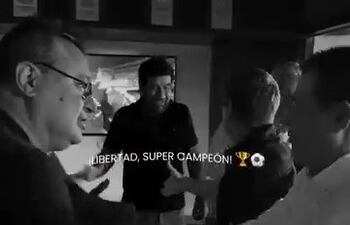 El senador Gustavo Leite celebra junto a Horacio Cartes con un apretón de manos, ayer tras el partido en el que Libertad campeonó.