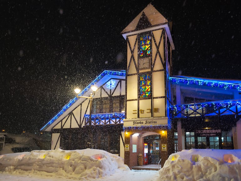 Vista nocturna de la estación de tren de Niseko, Japón, durante las fuertes nevadas de invierno.