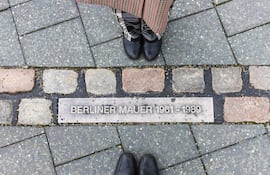 Línea conmemorativa del Muro de Berlín, con personas a cada lado.