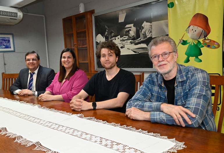 Enrique Alfonso con traje y gafas, María Victoria Sosa en blusa rosa, Ernesto Estigarribia en camiseta negra, Alexei Utkin en camisa a cuadros, todos en reunión amena.