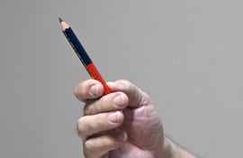 William Wilka sostiene un lápiz bicolor, mostrando que eligió el color azul, el de la libertad, para esbozar la proclama libertaria que el Gral. Andrés Rodríguez leyó y se emitió por radio aquel 2 y 3 de febrero de 1989.