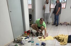 Miguel Insfrán, alias Tío Rico, (con remera verde) en cuclillas. A su alrededor las pertenencias que guarda en su celda del penal de Minga Guasu, allanada esta mañana luego del asesinato del teniente coronel Guillermo Moral.