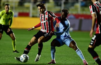 El centrocampista del San Pablo, Damián Bobadilla y el delantero de Bolívar, Dairon Asprilla, disputan el balón durante el partido de ida de los octavos de final, en el estadio Hernando Siles en La Paz.